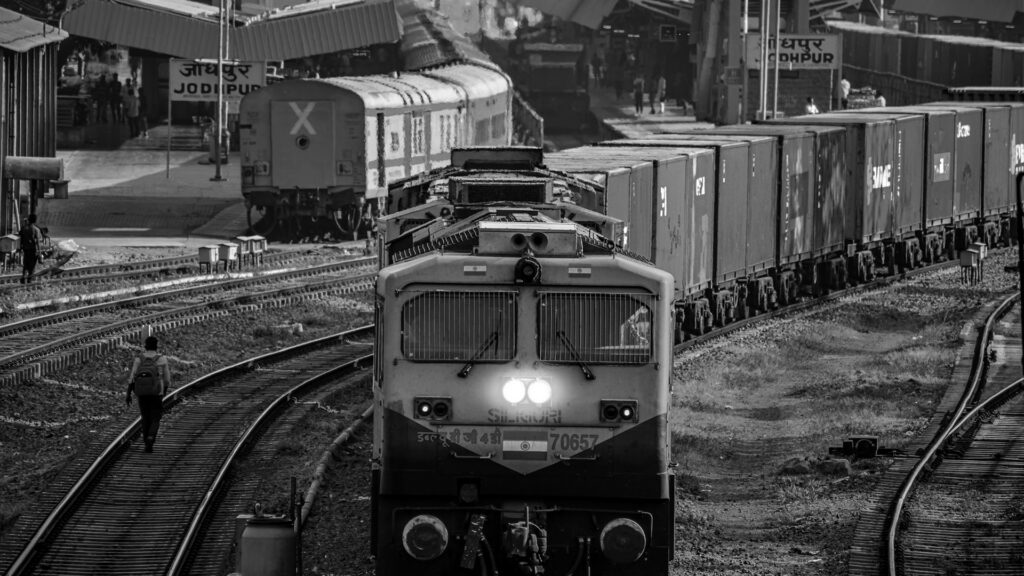 Yellow and black train on rail tracks during daytime.