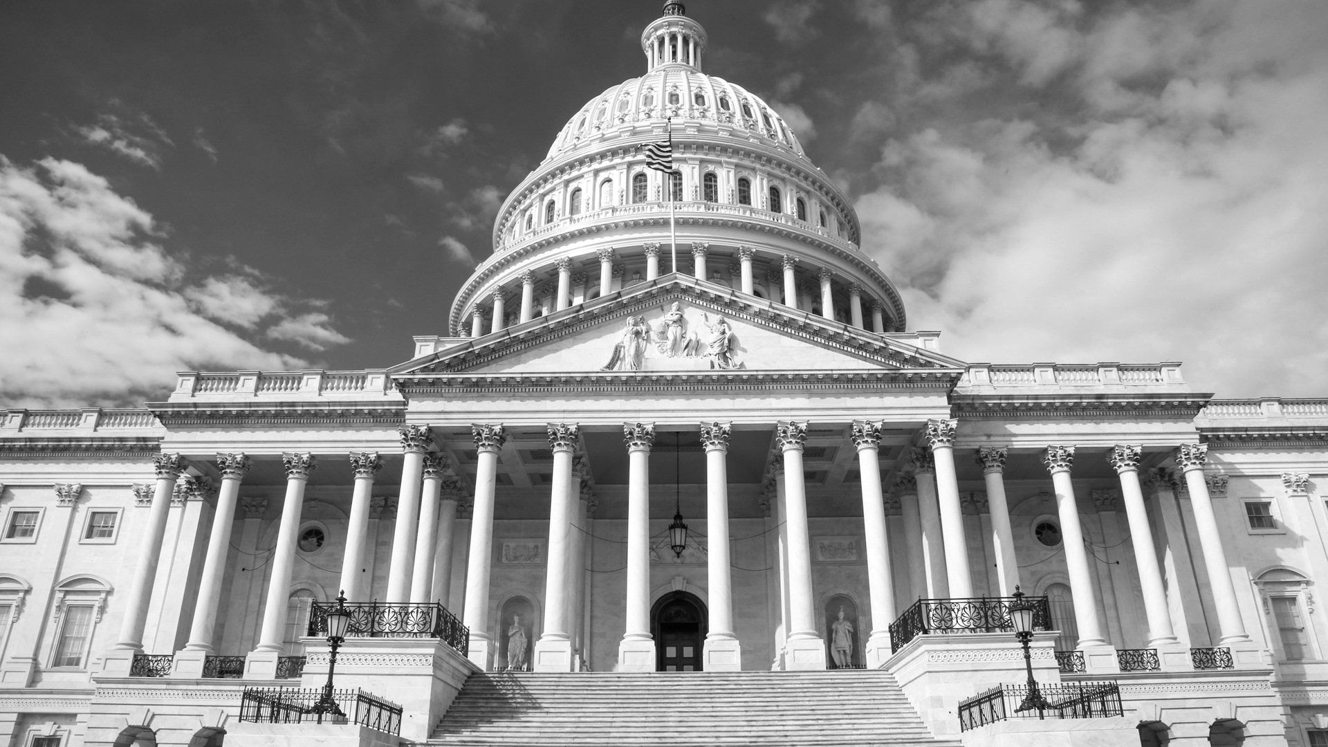 The United States Capitol building with its white dome against a blue sky.