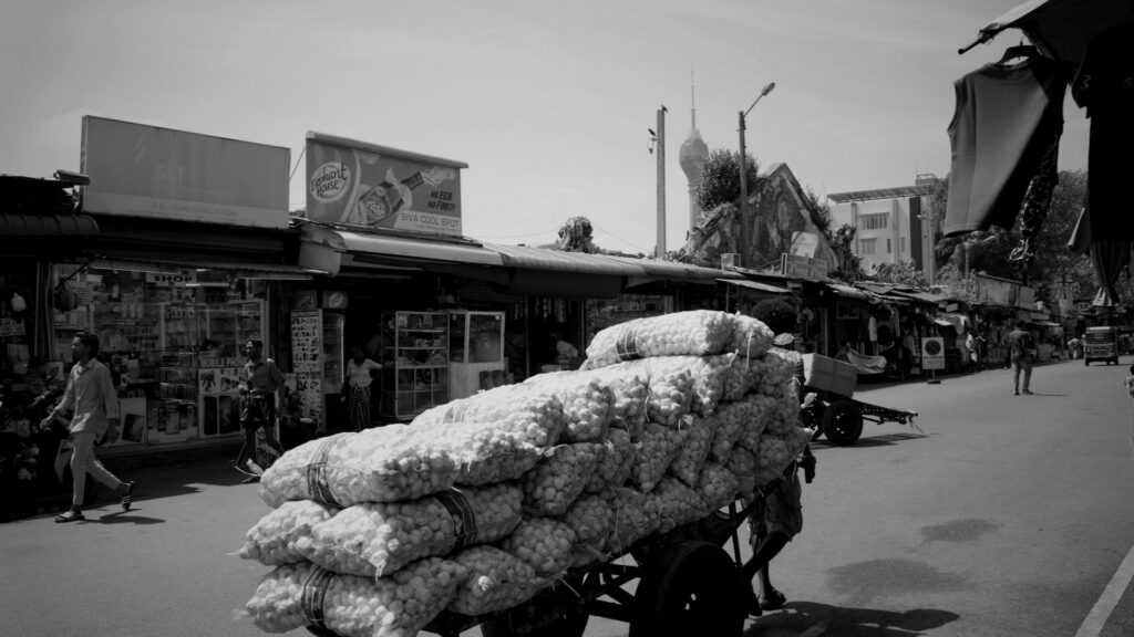 Cart loaded with sacks of produce on a street.