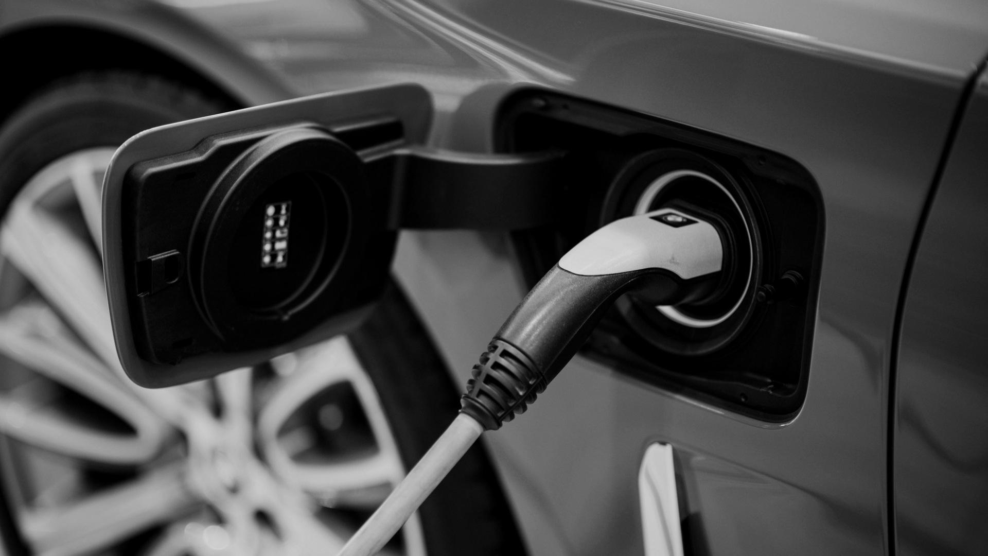 Electric vehicle charging cable plugged into car.