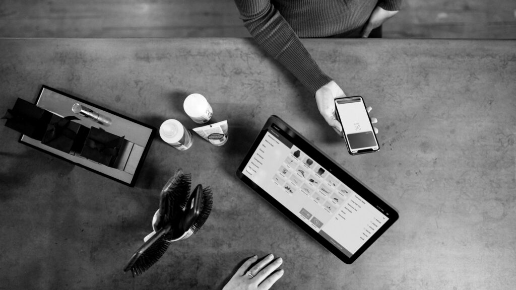 Person holding smartphone beside tablet computer.