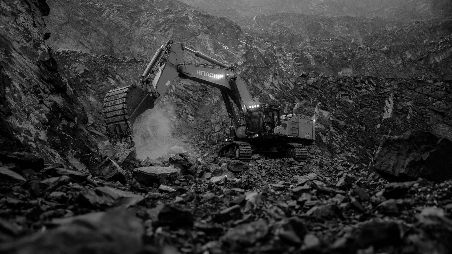 An orange excavator digging through a rocky area.