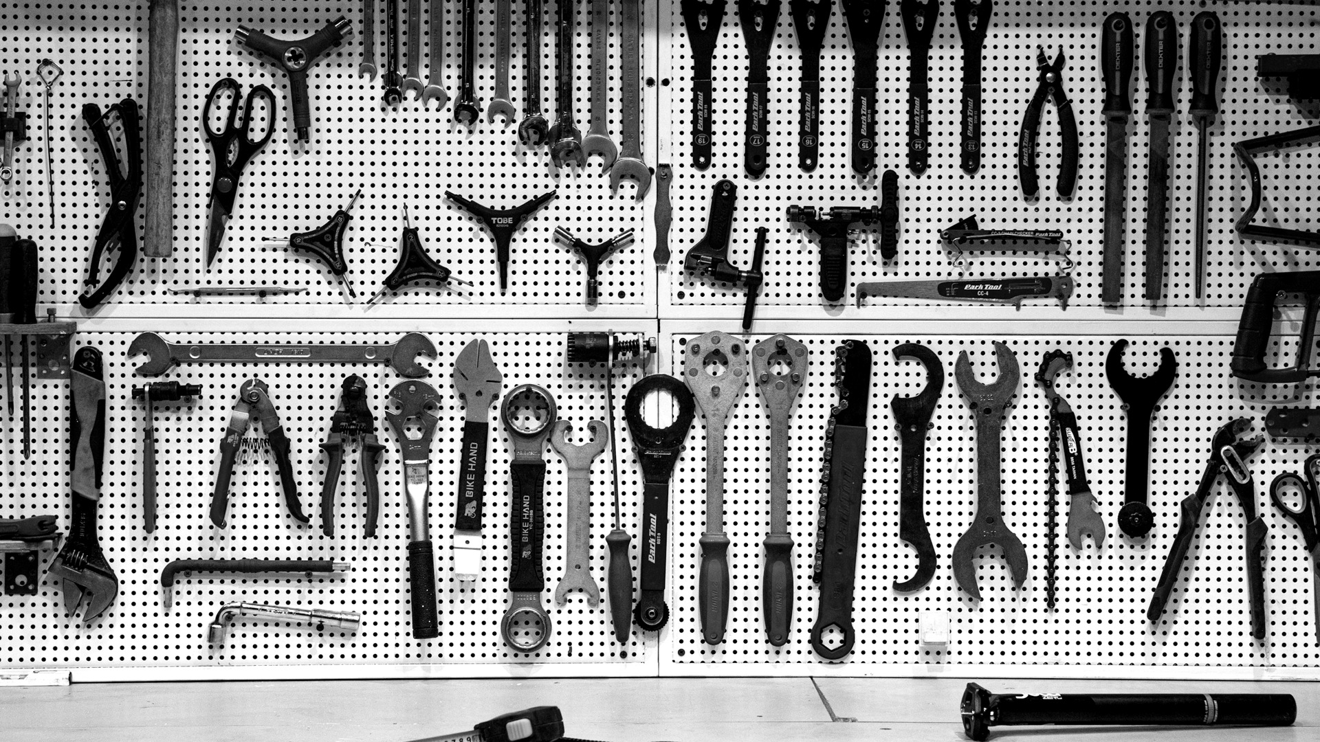 A bunch of tools hanging up on a wall.