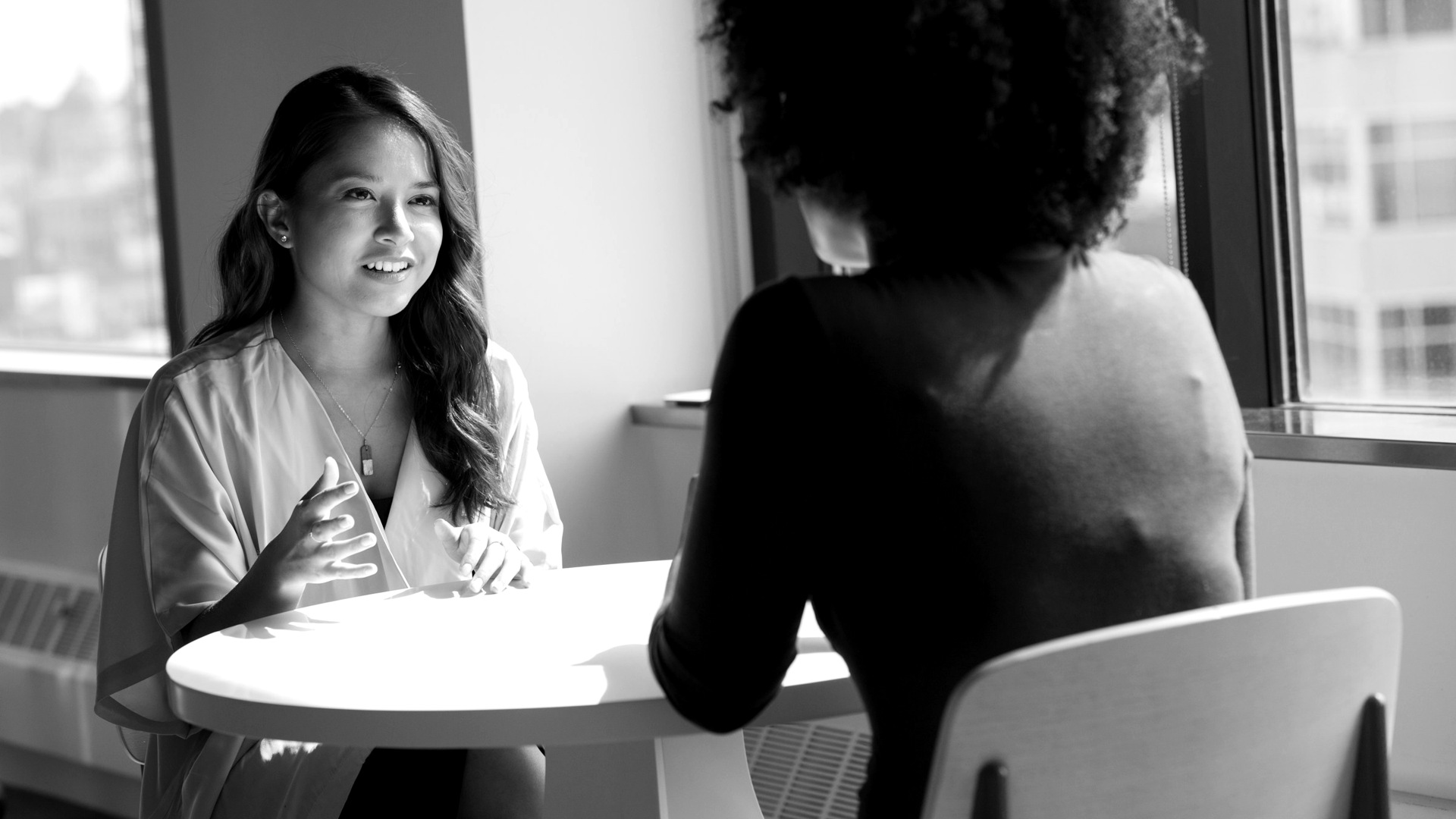Two women sitting on chair.