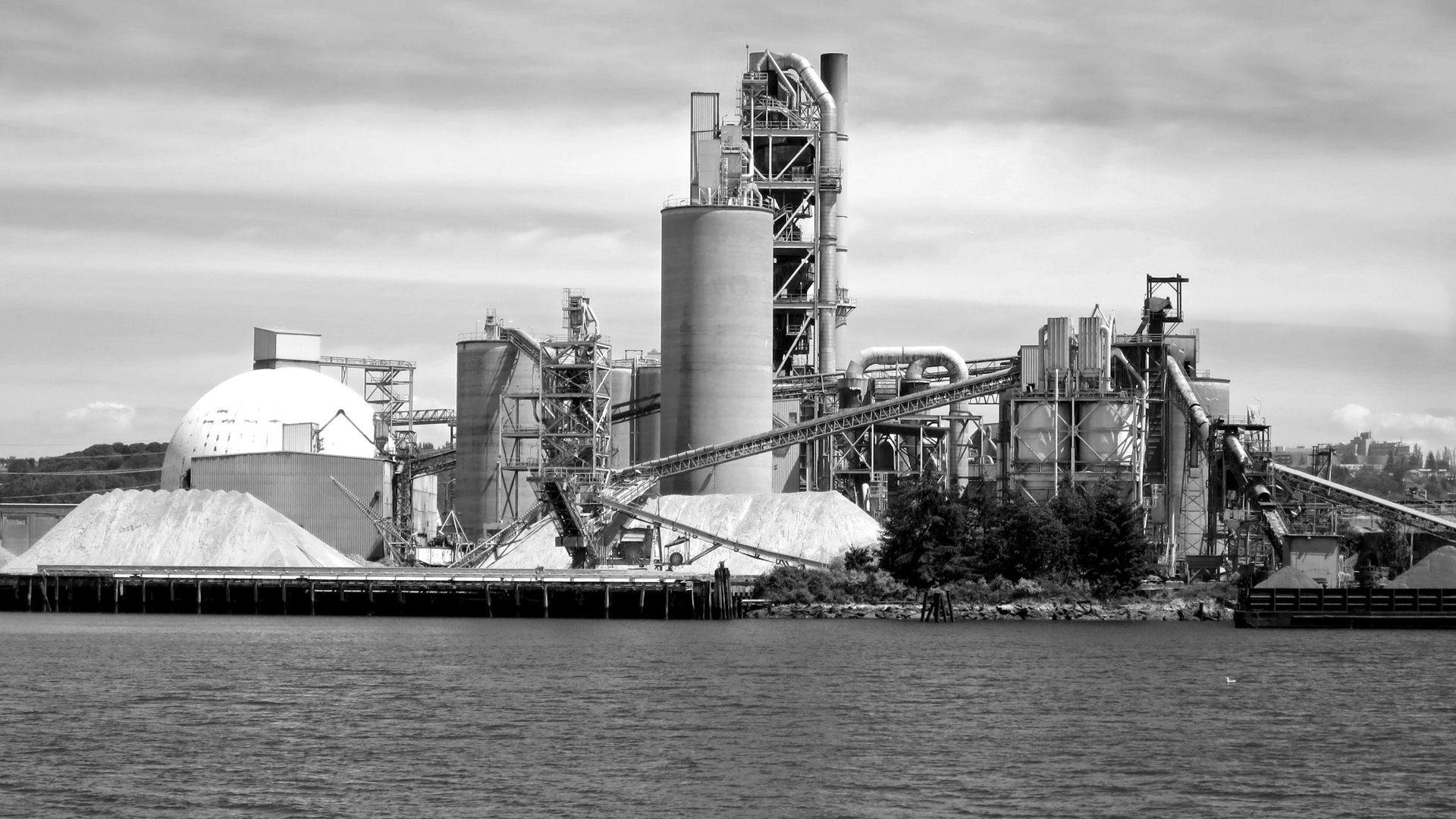 A large factory building next to a body of water.