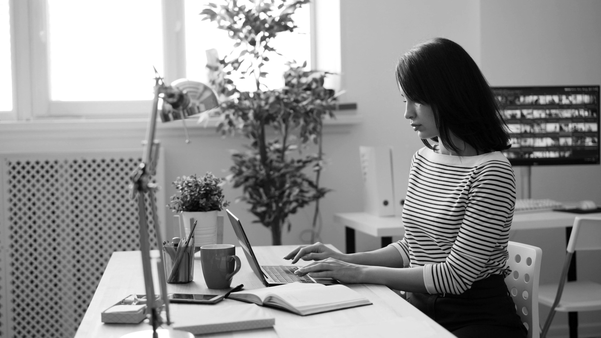 A woman sitting at a desk using a laptop computer.