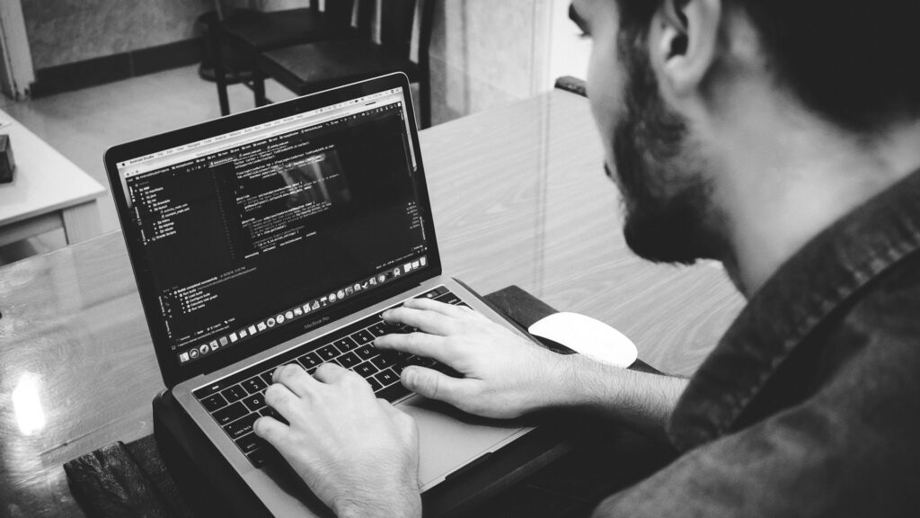 Man programming using laptop.