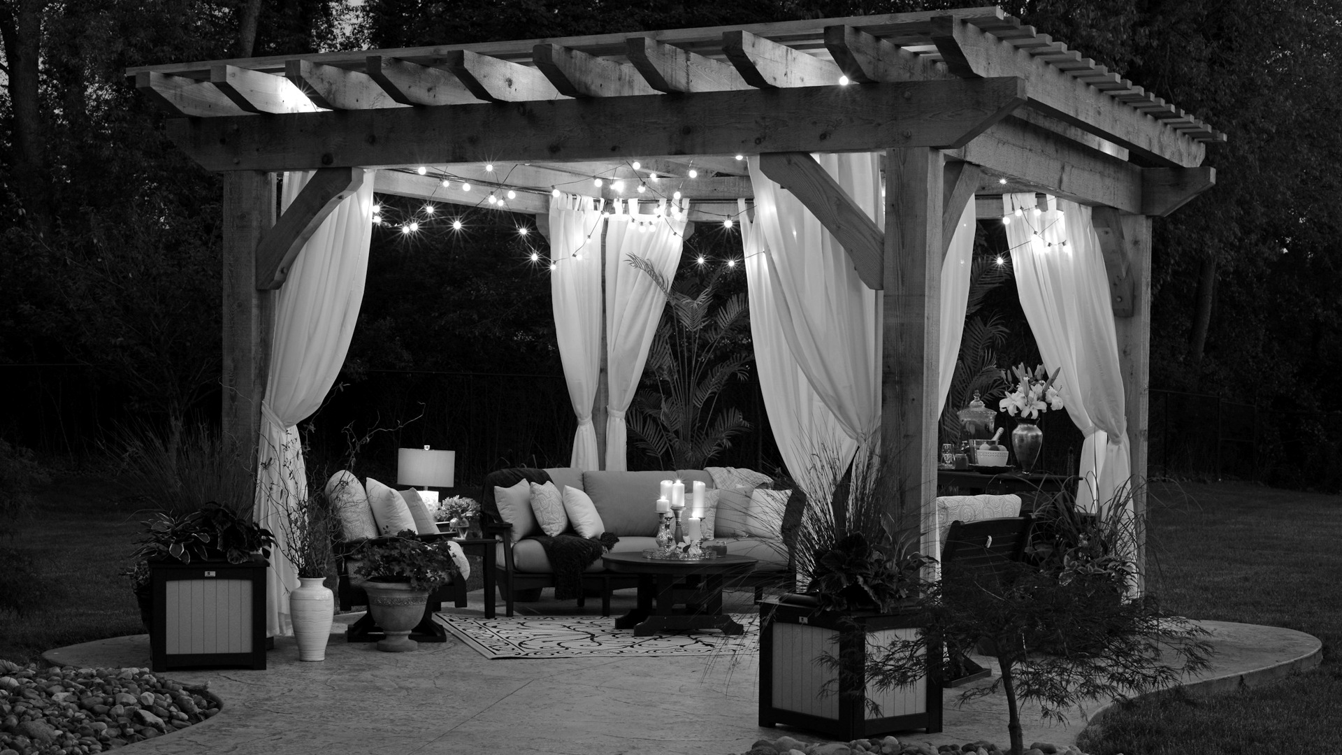 Photo of gazebo with curtain and string lights.