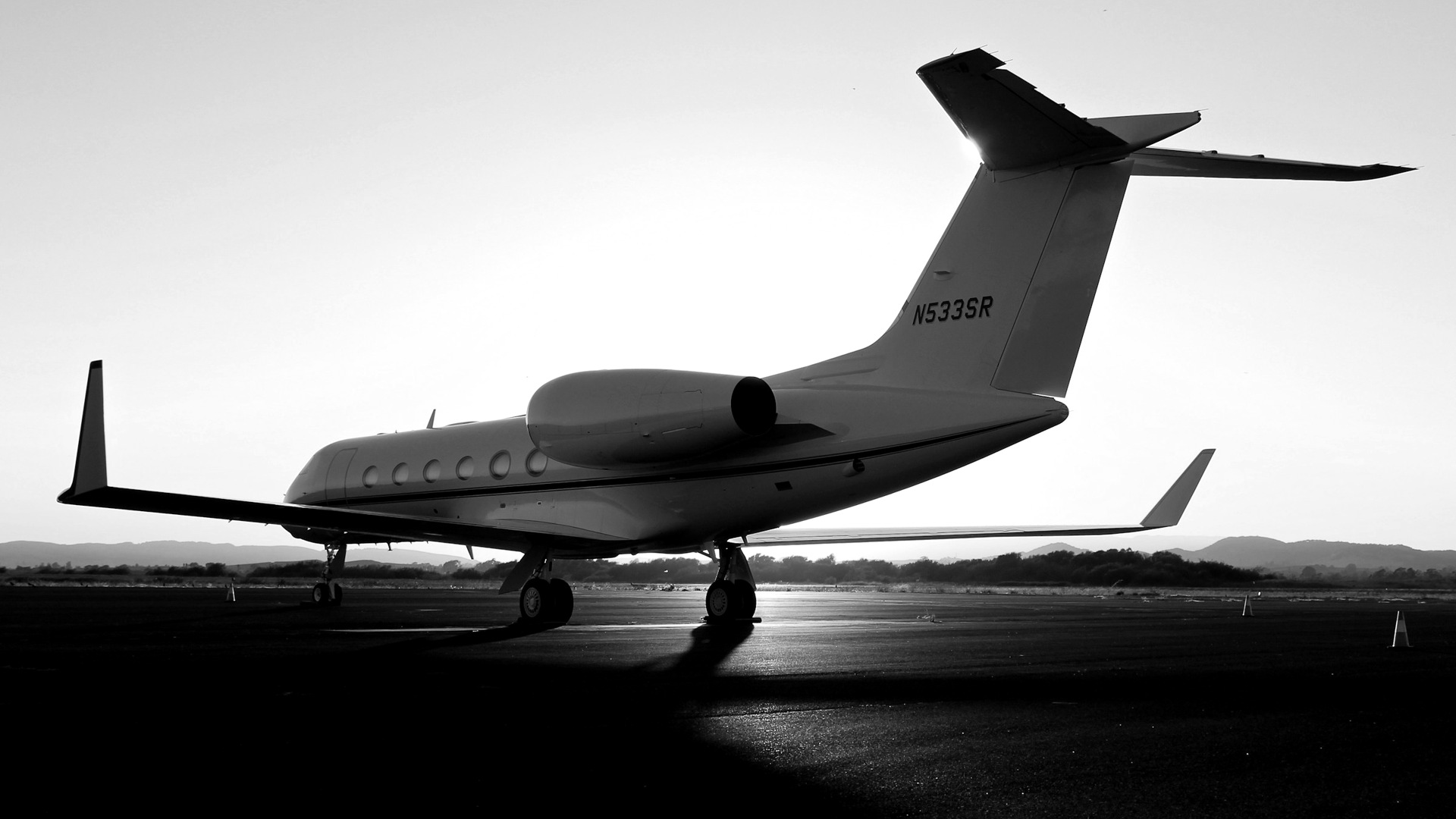 A white private jet on an airport tarmac during the golden hour.